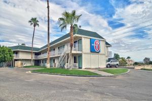 a hotel with a palm tree in front of it at Motel 6-Yuma, AZ - East in Yuma