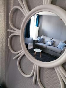 un soggiorno con divano e specchio di studio de Charme hyper centre a Boulogne-sur-Mer