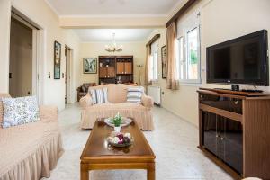 a living room with a couch and a tv at STEFANOS HOUSE in Argostoli