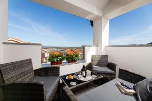 a balcony with a table and chairs with a view at App Kokotić in Čižići