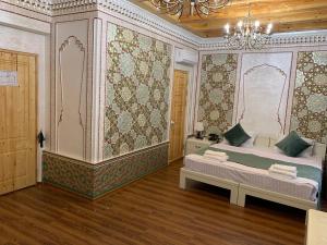 - une chambre avec un lit et un lustre dans l'établissement Shohnishin Boutique, à Boukhara