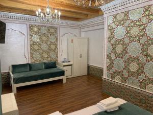 a living room with a couch and a wall with tiles at Shohnishin Boutique in Bukhara