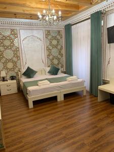 Schlafzimmer mit einem Bett und einem Kronleuchter in der Unterkunft Shohnishin Boutique in Buxoro