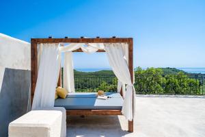 a bed with a canopy on a balcony at House Abatros in Babino Polje