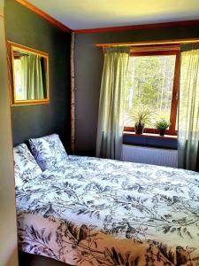 a bedroom with a bed and a window at Schnieders1German forest B&B in Harmånger