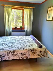 a bed sitting in a bedroom with a window at Schnieders1German forest B&B in Harmånger