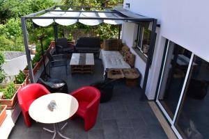 un patio con sillas y mesas rojas y una sombrilla en la casa gastounette, en Maiorca