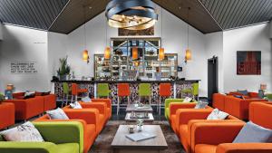 a restaurant with orange and green chairs and a bar at Hotel Diehlberg in Olpe