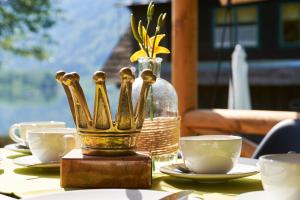 una mesa con tazas y un jarrón encima en Comfort Safarizelt direkt am Ossiachersee en Steindorf am Ossiacher See