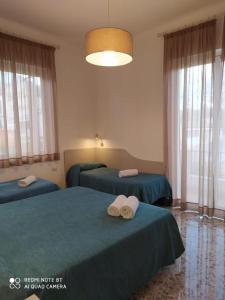 a bedroom with two beds with towels on them at Hotel Maria in Castellabate