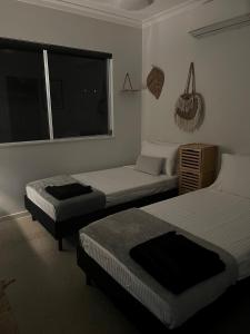 Zimmer mit 2 Betten und einem Fenster in der Unterkunft Beautiful large home available in tropical north Queensland in Port Douglas