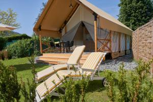 - deux chaises assises devant une tente dans l'établissement Comfort Safarizelt direkt am Ossiachersee, à Steindorf am Ossiacher See