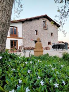 a building with a fountain in front of a garden at Agroturismo Erlete Goikoa -ESTAMOS EN EL CAMINO DE SANTIAGO -WE ARE ON THE CAMINO DE SANTIAGO in Deba