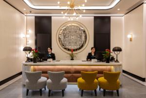 two women sitting at a reception desk in a lobby at H10 Palazzo Galla in Rome