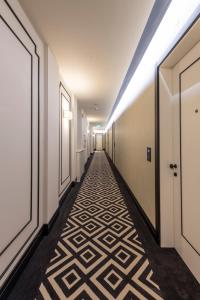 a hallway with a carpet with a geometric pattern on the floor at H10 Palazzo Galla in Rome
