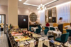 a dining room with tables with plates of food at H10 Palazzo Galla in Rome