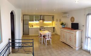a kitchen and dining room with a table and chairs at Sardegna Beach Cala Reale in Santa Marinella