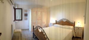 a bedroom with a bed and a chair in a room at Sardegna Beach Cala Reale in Santa Marinella