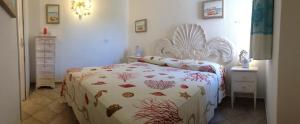 a bedroom with a bed with a fish themed bedspread at Sardegna Beach Cala Reale in Santa Marinella