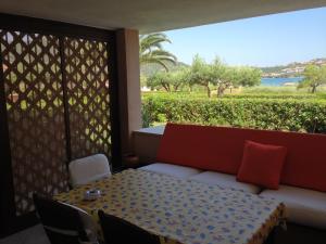 a room with a table and a couch and a window at Sardegna Beach Cala Reale in Santa Marinella