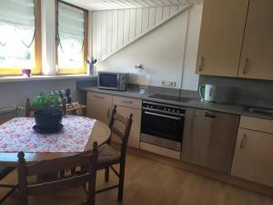 a kitchen with a table and a stove and a table and chairs at Ferienwohnung Klaus in Wolfegg