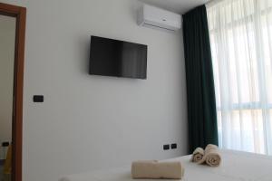 1 dormitorio con 1 cama y TV en la pared en Studio 60 Holiday, en Galatina