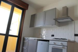 una cucina con mobili bianchi, un lavandino e una finestra di Studio 60 Holiday a Galatina Altre 9 foto