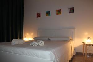 Un dormitorio con una cama blanca con toallas. en Studio 60 Holiday, en Galatina