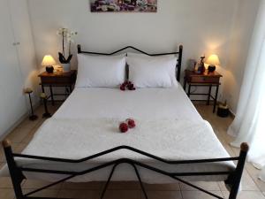 a bedroom with a large white bed with fruit on it at Comfy Alykes Apartment, Volos in Volos