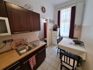 a kitchen with a sink and a table with chairs at Marble Apartment -near Buda castle in Budapest