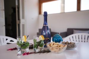 a table with a bottle of wine and bowls of food at Meraviglia d'Otranto in Otranto