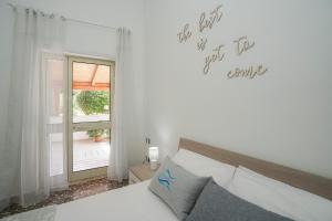 a white bedroom with a bed and a window at Meraviglia d'Otranto in Otranto