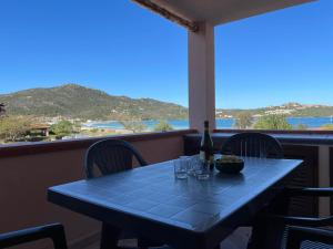 a table with a bottle of wine and glasses on a balcony at Sardegna Beach Cala Reale in Santa Marinella