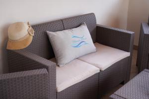 a wicker chair with a pillow sitting on it at Meraviglia d'Otranto in Otranto