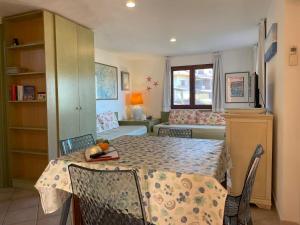 a kitchen with a table and chairs and a living room at Sardegna Beach Cala Reale in Santa Marinella