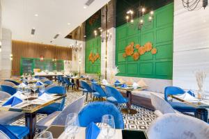 a dining room with tables and blue chairs at Adela Boutique Hotel - Infinity Pool in Da Nang