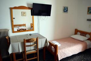 a small bedroom with a bed and a mirror at Mega Apartments in Tyros