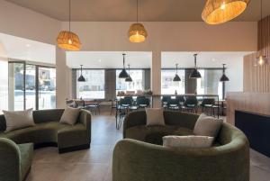 - un salon avec des canapés et une salle à manger dans l'établissement Oliva Welcoming Apartments, à Proença-a-Nova