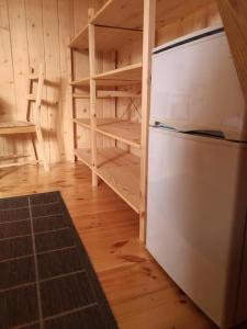 a kitchen with a refrigerator and some shelves at Przystań Kajakowa Zakole in Buda Ruska