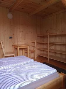 a room with a bed and a table and shelves at Przystań Kajakowa Zakole in Buda Ruska