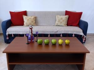 a coffee table with four green apples on it at Comfy Alykes Apartment, Volos in Volos