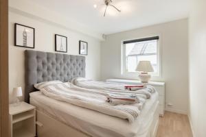 a bedroom with a large bed with a gray headboard at Central top floor apartment in Stavanger
