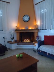 a living room with a fireplace with a clock at Comfy Alykes Apartment, Volos in Volos
