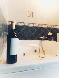 eine Flasche Wein am Rande einer Badewanne in der Unterkunft The perfect place to relax Bedroom with hot tub, beautiful tropical garden area. Bbq and big open spaces through all the house.It is located in a quiet place, but still 5 min away from the touristic Puerto Rico and walking distance from the beach in Mogán