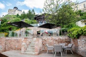 a table and chairs with umbrellas on a brick wall at ATRIO Apartments 2 in Trenčín