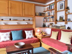 a living room with two red couches and bookshelves at Appartement Méribel, 3 pièces, 6 personnes - FR-1-180-155 in Méribel