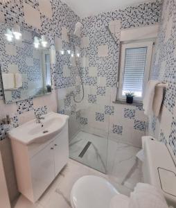 Baño blanco con aseo y lavamanos en Apartments Paklenica, en Starigrad-Paklenica