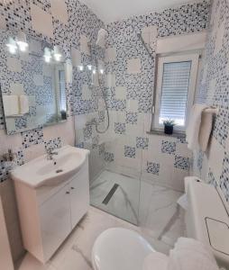 a white bathroom with a toilet and a sink at Apartments Paklenica in Starigrad-Paklenica