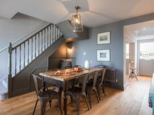 a dining room with a wooden table and chairs at Marchbourne in St Ives