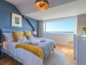a bedroom with a bed with a large window at Marchbourne in St Ives